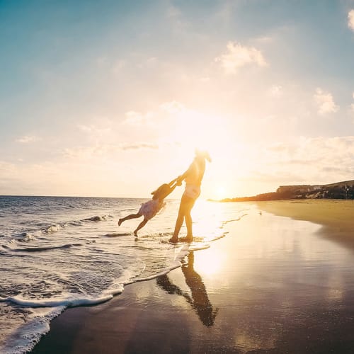 Mother and daughter having fun on tropical beach