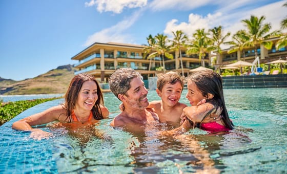 Family enjoying time together in a pool at Timbers Kauai